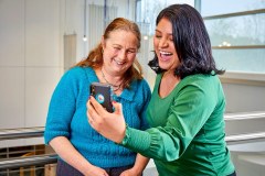 lifestyle photography of Getinge two women laughing together at a phone for Getinge in Merrimack, NH