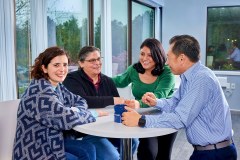 lifestyle photography of Getinge group of 4 sitting at a table talking for Getinge in Merrimack, NH