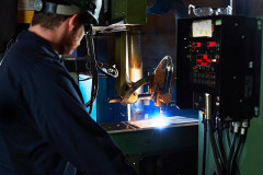 lifestyle photography of man watching a machine weld 