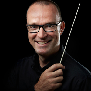 male headshot photography holding a conductor stick with black background male headshot photography holding a conductor stick with black background