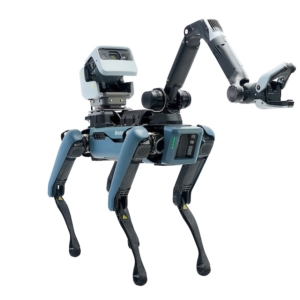High-angle industrial photography of a blue Boston Dynamics Spot robot equipped with a specialized robotic arm and grasper. The image captures the robot in a dynamic stance, emphasizing the sophisticated engineering of its articulated joints and the front-facing camera housing.