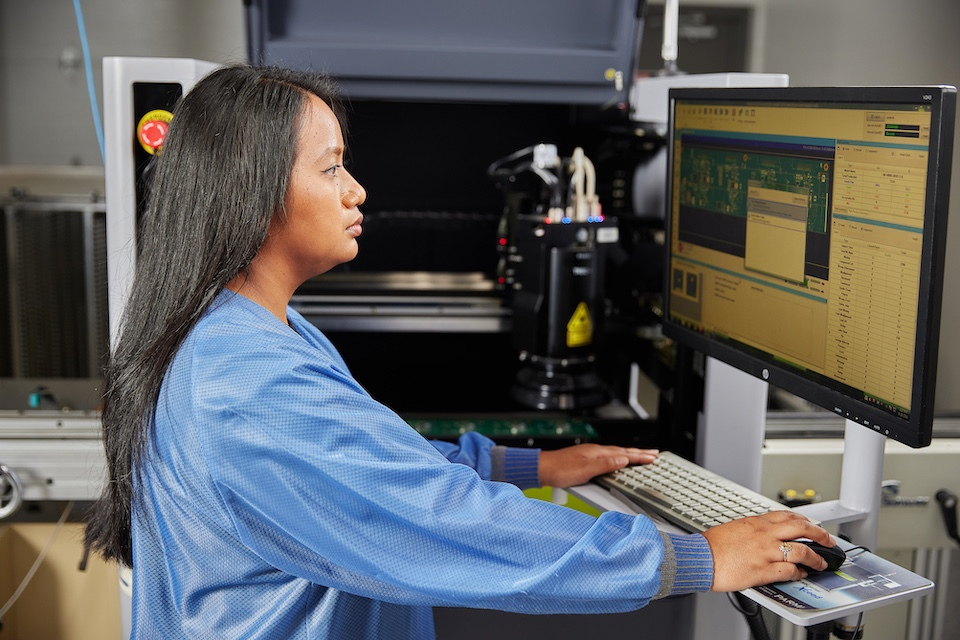 onsite lifestyle photography of female worker inspecting a circuit board for Accutronics of Chelmsford, MA.