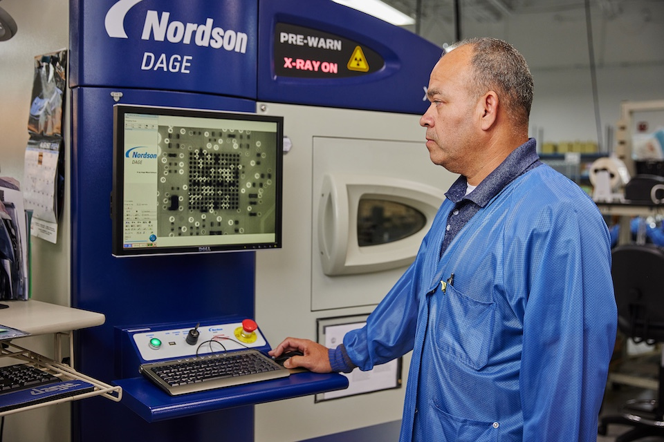 Accutronics onsite lifestyle photography of a male worker using a monitor attached to machine for Accutronics in Chelmsford, MA