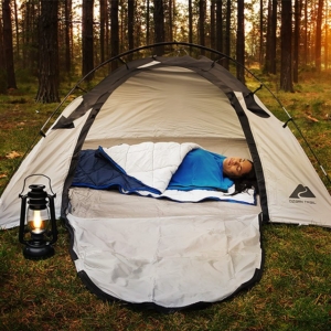 Lifestyle photography of a woman sleeping in Aksafara sleeping bag liner in a tent outside for Aksafara in Shrewsbury, MA