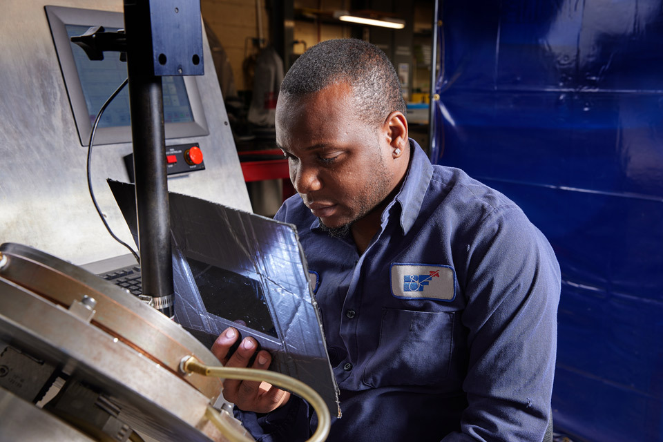 lifestyle photography of male employee inspecting machine for B and F Machines of New Britain, CT.