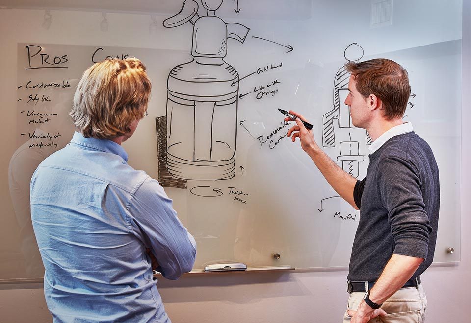 lifestyle photography of two men observing a sketch of a product on white board for Datum of Watertown, MA.