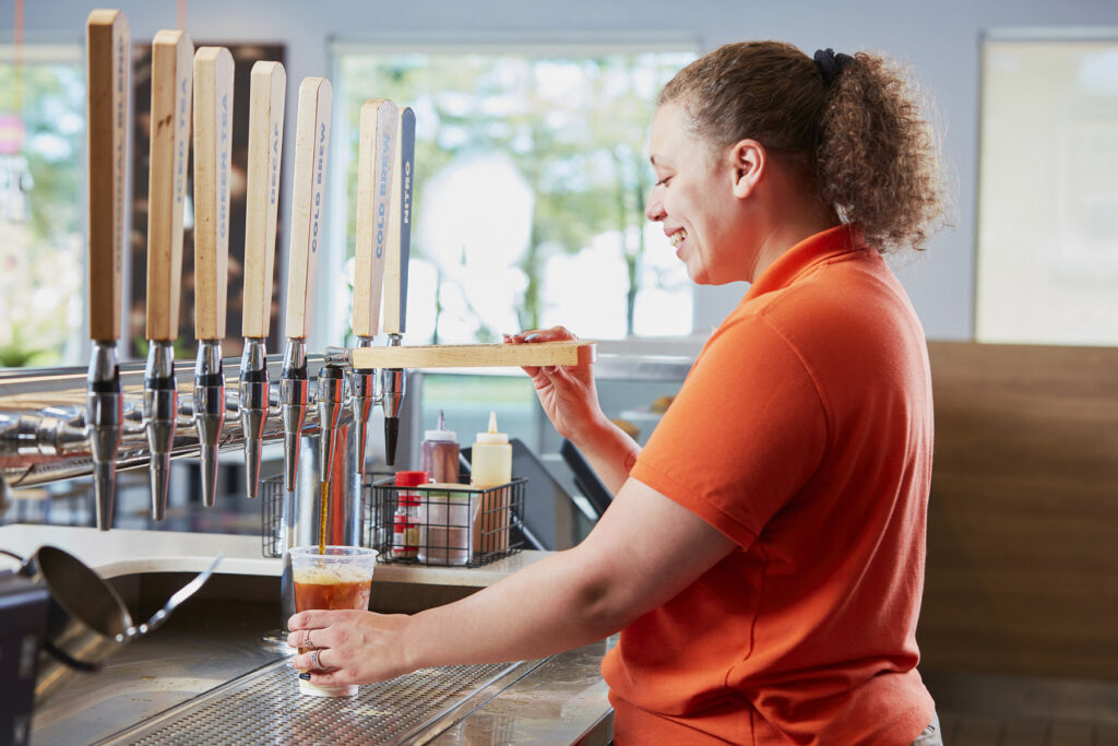 lifestyle photography of Dunkin employee making coffee for Dunkin Donuts