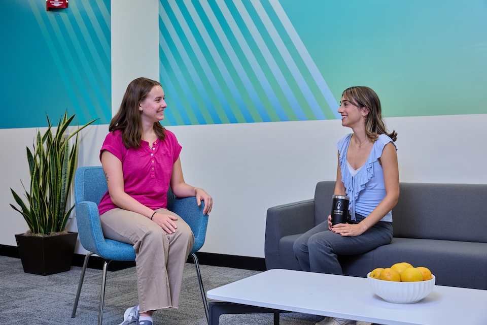 Two female employees conversing in employee lounge at Teradyne of North Reading, MA.