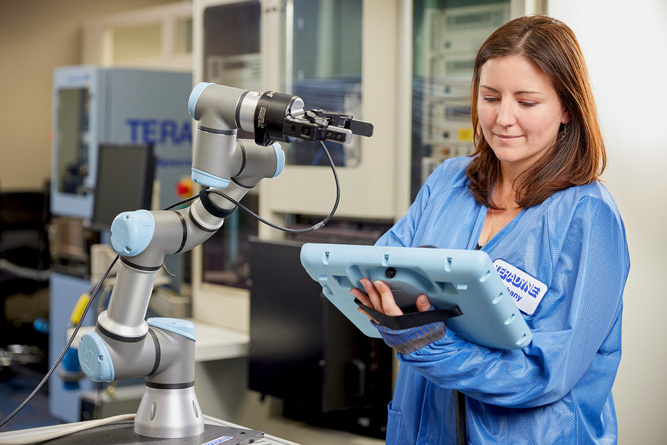 lifestyle photography of female Teradyne employee using a tablet next to a machine for Teradyne of North Reading, MA.