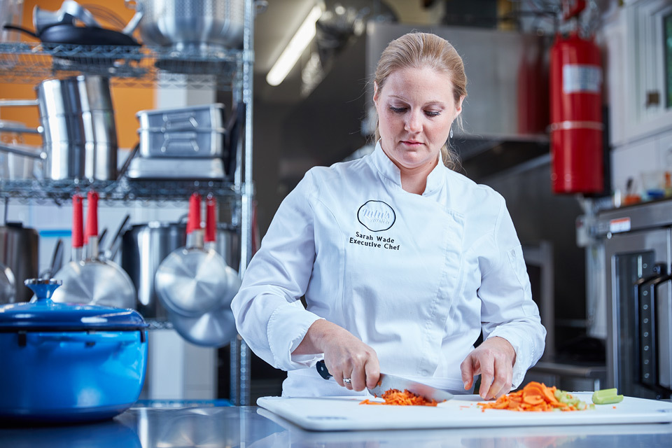 Lifestyle photography of Chef Sarah Wade cutting vegetables in her kitchen