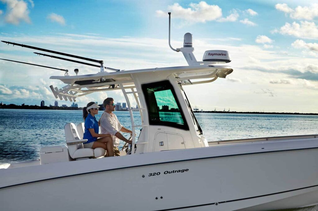 lifestyle photography of a male driving Quantum boat with female passenger for Raymarine Teledyne-FLIR of Hudson, NH.