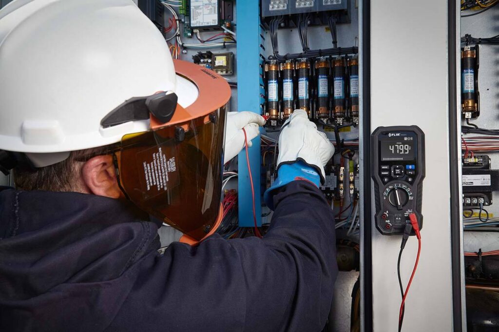 lifestyle photography of man using FLIR DM284 for FLIR lifestyle photography of man using FLIR DM284 while handling wires for Teledyne-FLIR of Hudson, NH.
