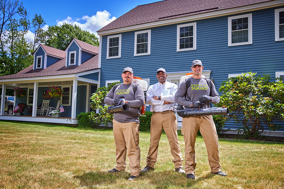 lifestyle photography of 3 mosquito squad employees standing in front of a house for Mosquito Squad
