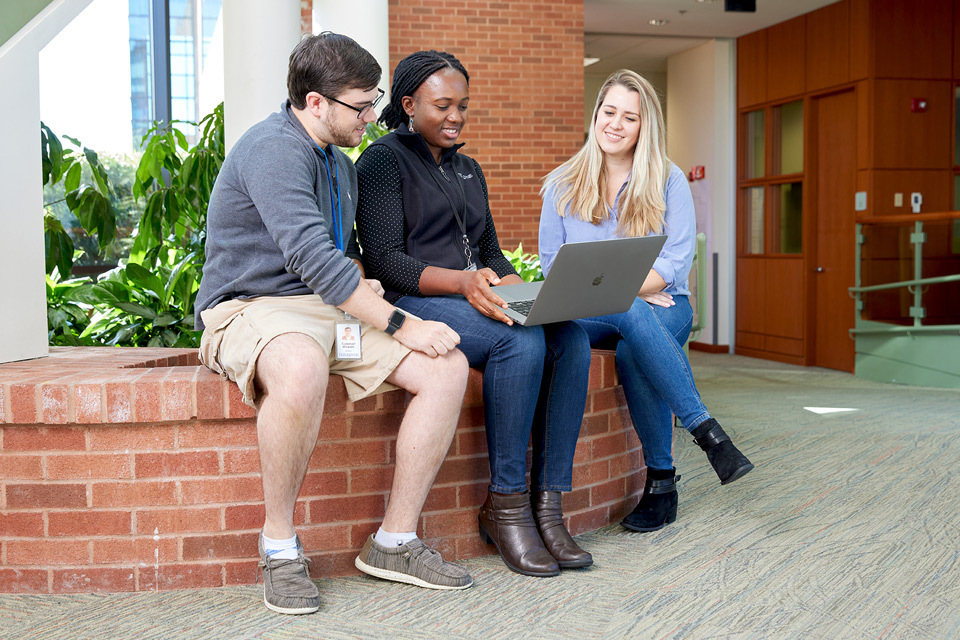 lifestyle photography of 3 employees sitting and talking in Teradyne headquarters of North Reading, MA.