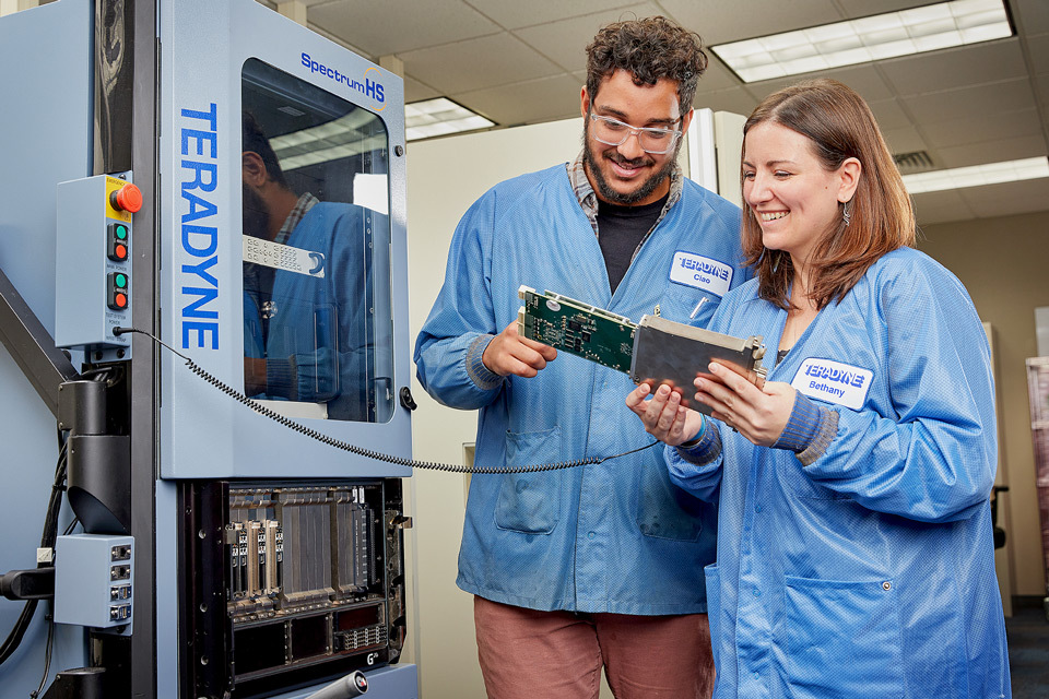 lifestyle photography of Teradyne employees wearing lab coats,testing circuit board for Teradyne of North Reading, MA.