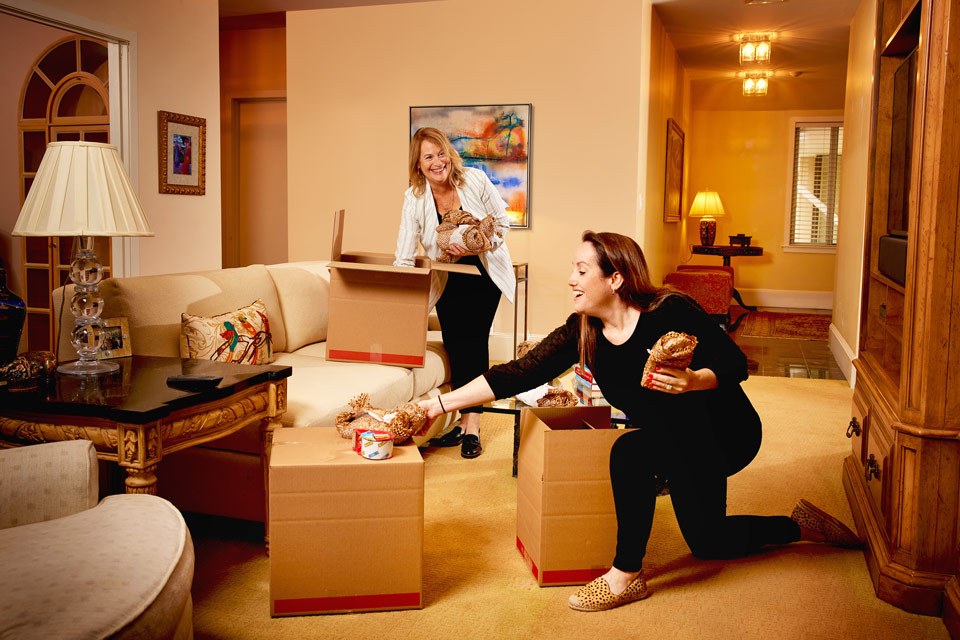 lifestyle photography of two women packing living room for a real estate and moving company in Needham, MA.