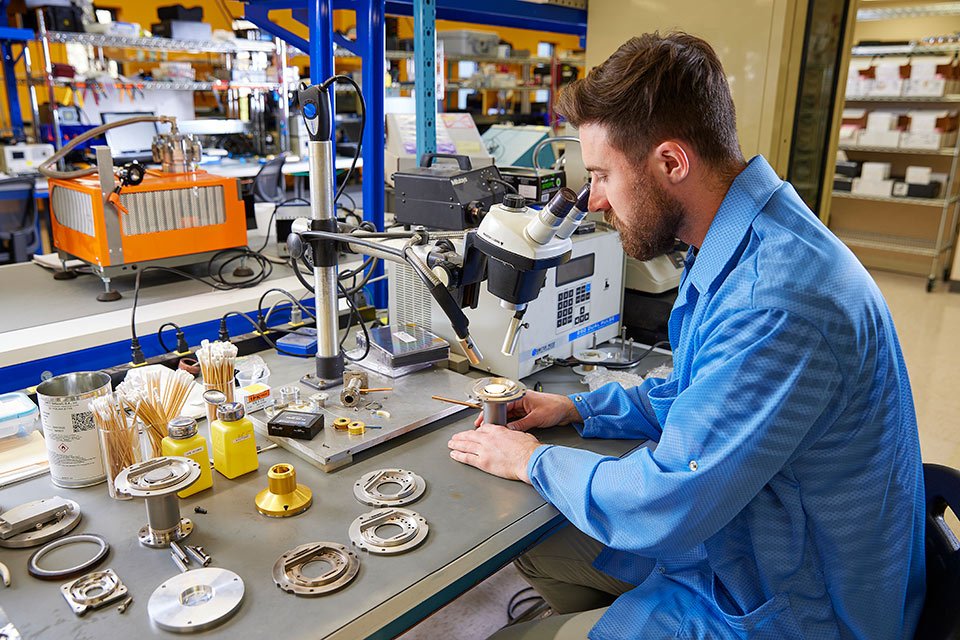 lifestyle photography of male technician seated at a desk assembling product for AIRS of Hudson, NH.
