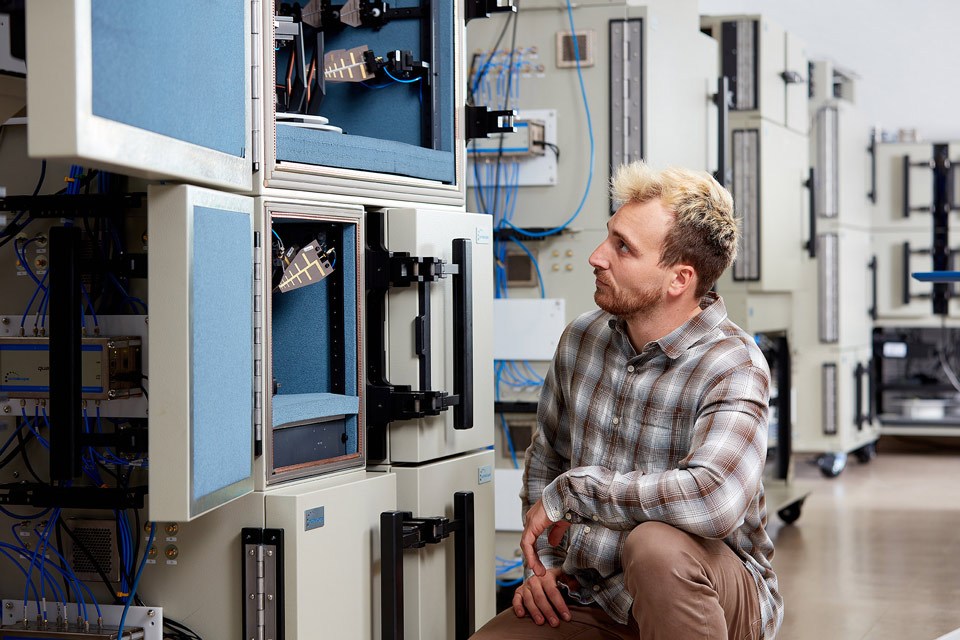 lifestyle photography of male employee knelt on ground looking into machine for Octoscope of Littleton, MA.