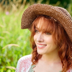 2G9A3383 portrait of woman outside smiling touching her hat
