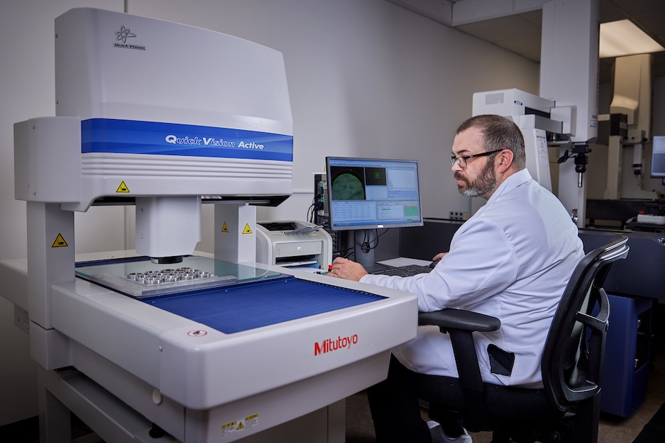 Onsite lifestyle photography of male worker inspecting product for Precision Technologies in Tyngsborough, MA.