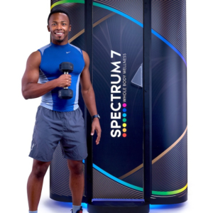 Product photography of male with dumbell standing in front of Spectrum 7 Red light machine for Suncapsule of North Andover, MA.