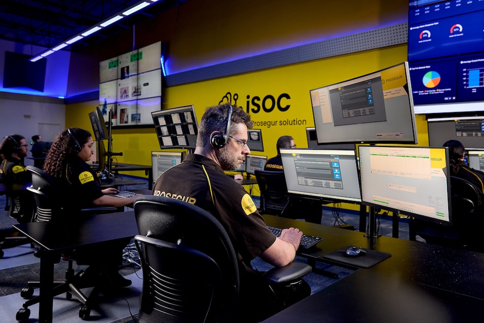 Lifestyle photography of prosegur security agents working in front of multiple monitors with headsets on for Prosegur of Lowell, MA.