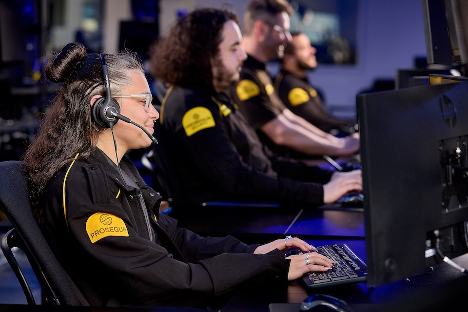 Lifestyle photography of prosegur security agents working at desk computers with headsets on for Prosegur of Lowell, MA.