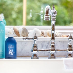Lifestyle photography of liquid hand soap and liquid dish soap products next to sink for Three Main of Boston, MA.