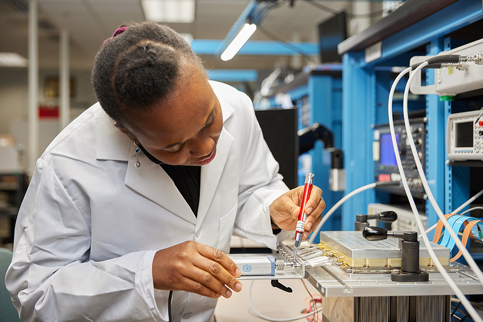 Onsite lifestyle photography of woman in lab coat working for Teradyne of North Reading, MA.