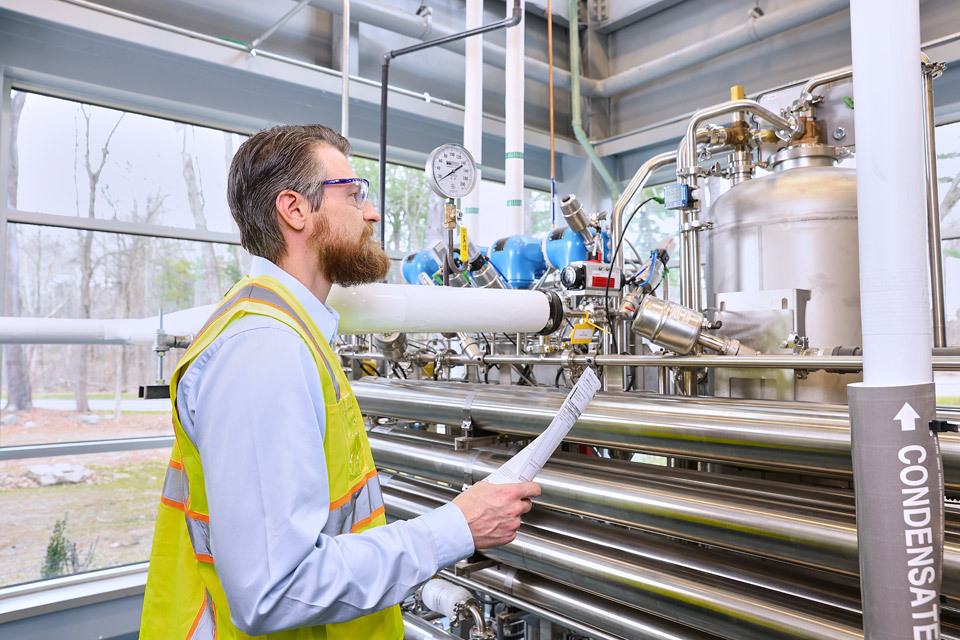 lifestyle photography of male in safety vest and protective goggles checking for quality control for Vibalogics in Boxborough, MA