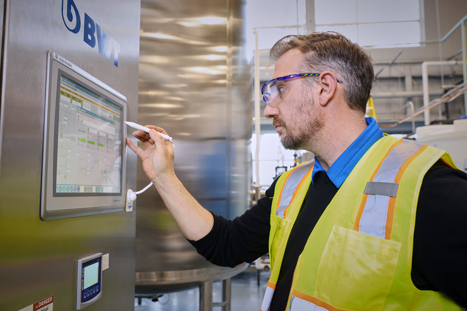 lifestyle photography of man in safety vest using monitor attached to machine for Vibalogics in Boxborough, MA